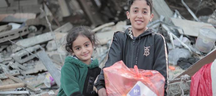 Des enfants tenant des kits d'urgence distribués par nos équipes.